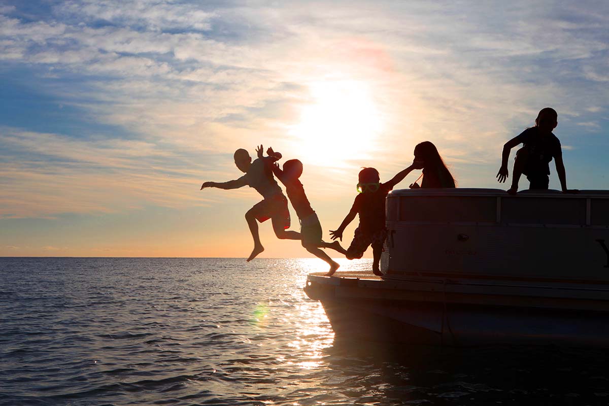 Kids playing on a boat at sunset in Barbados